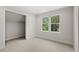 Bedroom featuring plush carpet, neutral walls, and a bright window overlooking the neighborhood at 102 Hammock Preserve Loop, Winter Garden, FL 34787