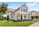 Attractive two-story home with a classic front porch and lovely landscaping enhancing the curb appeal and charm at 102 Hammock Preserve Loop, Winter Garden, FL 34787