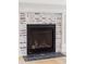 Close up of the stylish whitewashed brick fireplace with black hearth at 102 Hammock Preserve Loop, Winter Garden, FL 34787