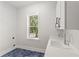 Bright laundry room with blue tile flooring, white cabinets and window view at 102 Hammock Preserve Loop, Winter Garden, FL 34787