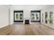 Open living area featuring wood floors, a fireplace, and glass doors offering natural light and charm at 102 Hammock Preserve Loop, Winter Garden, FL 34787