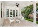 Covered patio featuring a ceiling fan, travertine flooring, and comfortable seating with direct views of the backyard at 102 Hammock Preserve Loop, Winter Garden, FL 34787