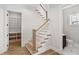 Elegant staircase with wood railing and banister, open to pantry and bathroom at 102 Hammock Preserve Loop, Winter Garden, FL 34787