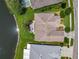 Aerial view of the property showing the roof, screened lanai, landscaping, and water view at 106 Winghurst Blvd, Orlando, FL 32828
