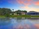 Beautiful backyard of single Gathering home with lake view, lush landscaping, and screened-in lanai at 106 Winghurst Blvd, Orlando, FL 32828