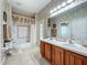 Well-lit bathroom boasts double sinks, decorative wallpaper, and a shower-tub combination at 106 Winghurst Blvd, Orlando, FL 32828