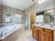 Well-lit bathroom featuring a glass enclosed shower, soaking tub, double vanity, and walk-in closet at 106 Winghurst Blvd, Orlando, FL 32828