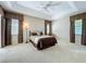 Comfortable bedroom featuring a tray ceiling, carpet flooring, ceiling fan, and bright windows at 106 Winghurst Blvd, Orlando, FL 32828