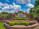 Well-maintained community entrance with brick signage, landscaping, and manicured shrubs at 106 Winghurst Blvd, Orlando, FL 32828