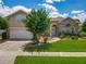 Charming two-story home with brick accents, landscaped yard and flowering tree at 106 Winghurst Blvd, Orlando, FL 32828
