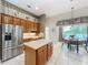 Open kitchen with stainless steel refrigerator, island, wood cabinets, breakfast nook and backyard views at 106 Winghurst Blvd, Orlando, FL 32828