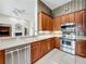Kitchen featuring stainless steel appliances, wood cabinets and a breakfast bar with a view to living room at 106 Winghurst Blvd, Orlando, FL 32828