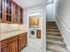 Laundry room features a washer, dryer, storage cabinets, sink, and stairs leading to the second floor at 106 Winghurst Blvd, Orlando, FL 32828