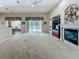 Bright living room with high ceilings, fireplace, and sliding glass doors to a patio area at 106 Winghurst Blvd, Orlando, FL 32828