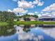 Back of house with a large lake and reflecting clouds on a sunny day at 106 Winghurst Blvd, Orlando, FL 32828