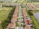 Aerial view of a neighborhood with golf course and houses with solar panels, covered back patios and hot tubs at 1097 Trappers Trail Loop, Davenport, FL 33896