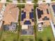Aerial view of a house with solar panels, a covered back patio and a hot tub in a fenced backyard at 1097 Trappers Trail Loop, Davenport, FL 33896