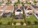 Aerial view of a house with solar panels, a covered back patio and a hot tub in a fenced backyard at 1097 Trappers Trail Loop, Davenport, FL 33896