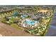 Aerial view of resort-style community pools, a water park, mini golf, and lush landscaping in a residential setting at 1097 Trappers Trail Loop, Davenport, FL 33896