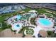 Aerial view of a resort-style pool area with slides, a lazy river, and other amenities in a beautiful community setting at 1097 Trappers Trail Loop, Davenport, FL 33896