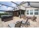 Covered back patio with a hot tub, outdoor kitchen and dining space with a fire pit surrounded by Adirondack chairs at 1097 Trappers Trail Loop, Davenport, FL 33896