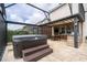 Covered back patio with a hot tub and outdoor kitchen and dining space with a dining table and a ceiling fan at 1097 Trappers Trail Loop, Davenport, FL 33896