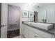 Well-lit bathroom features a double vanity with grey countertops, white cabinets, and laminate flooring at 1097 Trappers Trail Loop, Davenport, FL 33896