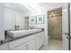 Bright bathroom featuring double vanity sinks, white cabinets, and a glass enclosed shower at 1097 Trappers Trail Loop, Davenport, FL 33896
