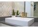 A minimalist bathroom sink with a white basin, gold faucet, and decorative plants at 1097 Trappers Trail Loop, Davenport, FL 33896