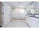 Contemporary bathroom features a large walk-in shower, sleek double vanity, and pristine white tile, designed for elegance at 1097 Trappers Trail Loop, Davenport, FL 33896