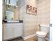 Stylish powder room featuring geometric wallpaper, a modern vanity, and complementary fixtures at 1097 Trappers Trail Loop, Davenport, FL 33896