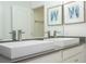 Modern bathroom featuring double vanity sinks, white cabinets, and a large mirror at 1097 Trappers Trail Loop, Davenport, FL 33896