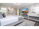 Bright bedroom with a wall-mounted TV, vanity area, and abstract art, creating a stylish retreat at 1097 Trappers Trail Loop, Davenport, FL 33896