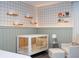 This Bedroom features a white crib, cloud shelving, and a cozy armchair and ottoman at 1097 Trappers Trail Loop, Davenport, FL 33896
