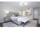 A modern bedroom with a upholstered headboard, bench, and stylish bedside tables, offering a relaxing space at 1097 Trappers Trail Loop, Davenport, FL 33896