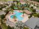 Breathtaking aerial view of a community pool, cabana, palm trees and lounge chairs at 1097 Trappers Trail Loop, Davenport, FL 33896