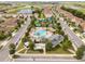 Aerial shot of a community pool, cabana and pool house surrounded by palm trees and lovely green spaces at 1097 Trappers Trail Loop, Davenport, FL 33896