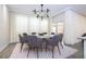 Elegant dining room with a modern chandelier, round table, and large windows with sheer curtains at 1097 Trappers Trail Loop, Davenport, FL 33896