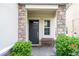 Inviting front porch with stone accents, a bench, and lush greenery at 1097 Trappers Trail Loop, Davenport, FL 33896