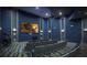Home theater with blue walls, tiered seating, projector, and screen for immersive entertainment experiences at 1097 Trappers Trail Loop, Davenport, FL 33896