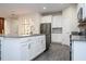 Open concept kitchen with stainless steel appliances, gray countertops and modern lighting fixture at 1097 Trappers Trail Loop, Davenport, FL 33896