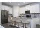 Modern kitchen featuring white cabinetry, stainless steel appliances, and a breakfast bar with seating at 1097 Trappers Trail Loop, Davenport, FL 33896