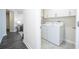 Laundry room features modern washer and dryer set, along with white cabinets and a hallway view at 1097 Trappers Trail Loop, Davenport, FL 33896