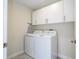 Bright laundry room features front loading washer/dryer set and white cabinets at 1097 Trappers Trail Loop, Davenport, FL 33896