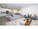 Open-concept living area with a large sofa, kitchen access, and stylish contemporary design at 1097 Trappers Trail Loop, Davenport, FL 33896