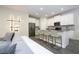 Open-concept living area showcasing modern lighting, a kitchen island with seating, and a sleek refrigerator at 1097 Trappers Trail Loop, Davenport, FL 33896