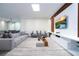 Bright living room featuring a large gray sofa, modern entertainment center, and stylish decor at 1097 Trappers Trail Loop, Davenport, FL 33896