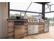 Stainless steel grill and outdoor kitchen area with built in mini fridge at 1097 Trappers Trail Loop, Davenport, FL 33896