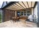 Covered outdoor kitchen area with dining, grill, and privacy screens at 1097 Trappers Trail Loop, Davenport, FL 33896