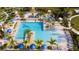 Aerial view of a large community pool, complete with lounge chairs, umbrellas, and lush tropical landscaping at 1097 Trappers Trail Loop, Davenport, FL 33896